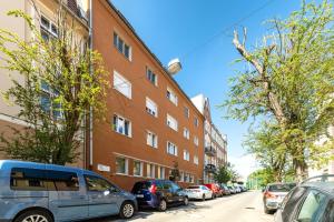 a row of cars parked on a street next to a building at Apartamenty Centrum - Moonlight in Opole