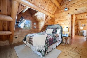 a bedroom with a bed in a wooden cabin at Pleasant View in Island Falls