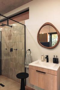ein Badezimmer mit Waschbecken und Dusche mit Spiegel in der Unterkunft TheHidden19Th in Moheme