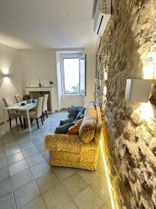 a living room with a couch and a stone wall at B&B Don Nicola in Bonefro