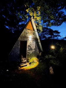 a small stone building with a door at night at Saruketha Cabana in Kegalle