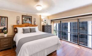 a bedroom with a large bed and a large window at Executive Center Hotel Honolulu in Honolulu