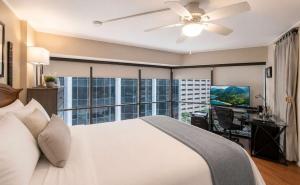 a bedroom with a white bed and a large window at Executive Center Hotel Honolulu in Honolulu