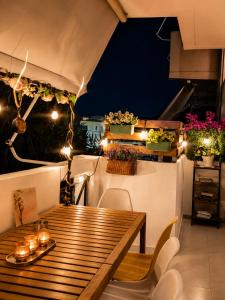 a table and chairs on a balcony at night at Erofili's Apartment ONLY 700 meters from the beach in Ialysos +28 photos