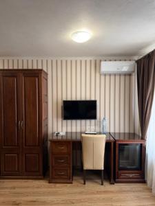 a room with a desk with a television and a chair at Villa Lamperti in Dyyda