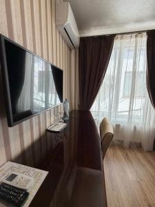 a room with a desk with a television on a wall at Villa Lamperti in Dyyda