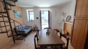 a living room with a dining room table and a staircase at Ferienhaus Casa Silenzio in Mandatoriccio +11 photos