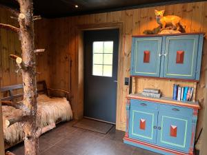 a room with a bed and a blue cabinet and a door at Trudvang in Tänndalen +16 photos