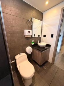 a bathroom with a toilet and a sink at Hotel Green Gold in Bucaramanga