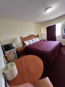 a hotel room with a bed and a table at Budget Inn Ocala in Ocala