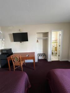 a hotel room with a desk and a bathroom at Budget Inn Ocala in Ocala
