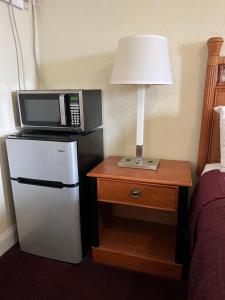 a microwave on top of a refrigerator next to a bed at Budget Inn Ocala in Ocala