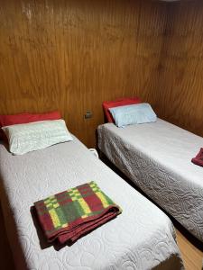 a room with two beds and a blanket on them at Hospedaje Ilabaca in Angol