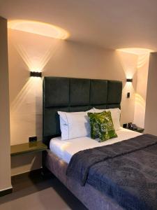 a bedroom with a large bed with a black headboard at Hotel Green Gold in Bucaramanga