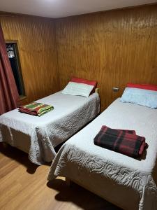 two beds in a small room with at Hospedaje Ilabaca in Angol