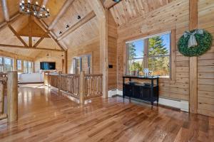 a large room with wooden walls and a large window at Pleasant View in Island Falls