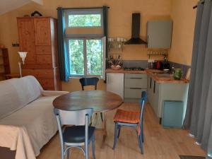 a kitchen with a table and chairs in a room at La Maisonnette Veyronne - Gîte neuf in Aubres