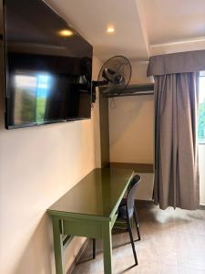a green table in a room with a fan at Hotel Green Gold in Bucaramanga +18 photos