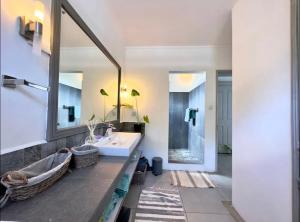 a bathroom with a sink and a mirror at Blue Zebra - Seaview Sunset Apartment 1 in Tamarin