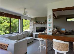 a living room with a white couch and a kitchen at Blue Zebra - Seaview Sunset Apartment 1 in Tamarin +5 photos