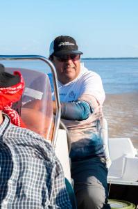 a man sitting on a boat in the water at Cabañas Bella Vista in Bella Vista