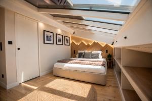a bedroom with a large bed and a skylight at La Verriere & Le refuge in Foix