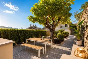 a patio with a table and a tree at La Verriere & Le refuge in Foix