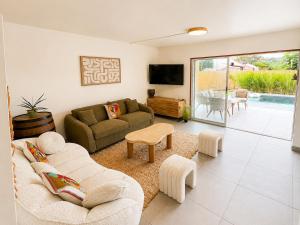 a living room with a couch and a tv at Villa Ma Cherry in Le Diamant