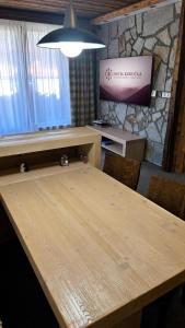 a wooden table in a room with a stone wall at Hotel Kukučka Apartament Janka C105 Tatranská Lomnica in Vysoké Tatry
