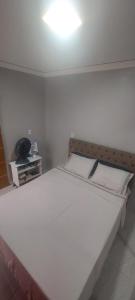 a bed in a room with a light on the ceiling at Conexão Cariri in Juazeiro do Norte