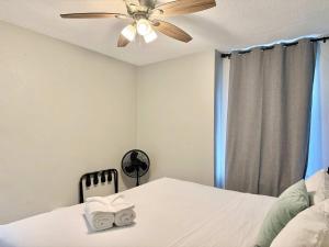 a bedroom with a ceiling fan and a bed with towels at Downtown Condo! Private Balcony! PT10F in Atlanta