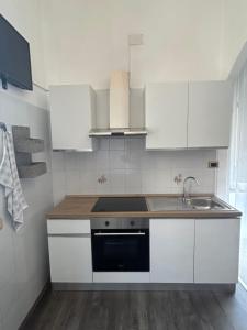 a kitchen with white cabinets and a sink at Casa mediterranea in Formia +4 photos