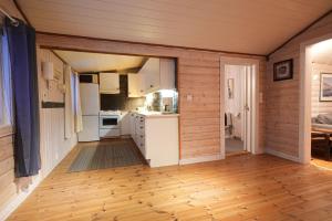 a kitchen with white appliances and a wooden floor at Little Paradise in Morfjorden +17 photos