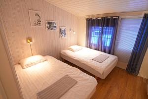 two beds in a small room with a window at Little Paradise in Morfjorden