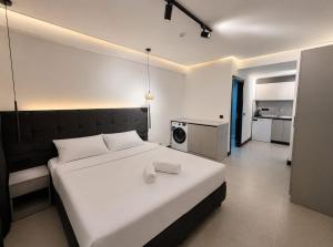 a bedroom with a large white bed and a kitchen at Bodrum has apart otel in Bodrum City