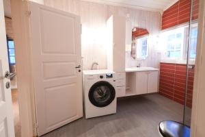 a bathroom with a washing machine and a sink at Little Paradise in Morfjorden