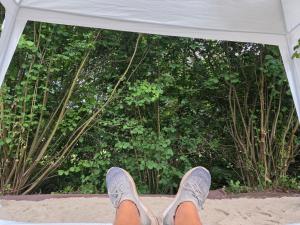 a person with their feet up on the sand in a tent at Acorn Creek Tented Camp in Nidda
