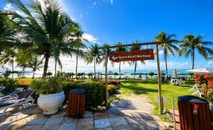 a sign for the beach at a resort with palm trees at Flat Carneiros - Hotel Marinas in Tamandaré