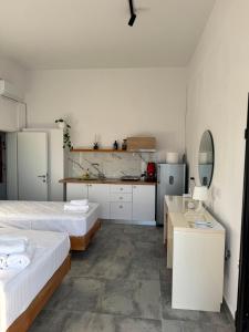 ein weißes Zimmer mit zwei Betten und einer Küche in der Unterkunft Solemare in Himarë + 51 Fotos