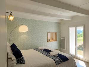 a bedroom with a bed and a large window at La Salagnac in Corrèze