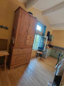 a large wooden cabinet in a room with a window at La Maisonnette Veyronne - Gîte neuf in Aubres +15 photos