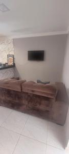 a large wooden couch in a room with a tv at Conexão Cariri in Juazeiro do Norte