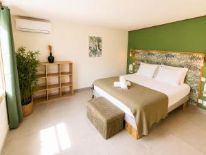 a bedroom with a large bed and a green wall at Villa Ma Cherry in Le Diamant +44 photos