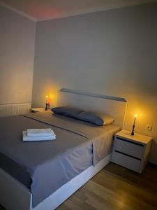 a bedroom with a large bed with two lamps on it at Apartament modern cu dormitor separat si balcon panoramic in Căuşeni