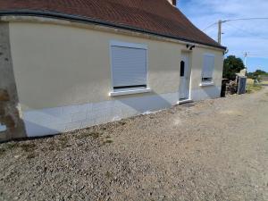 a white house with two windows and a driveway at Agréable Maison in Le Magny