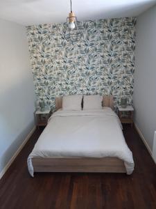 a bedroom with a large bed with a wall at Agréable Maison in Le Magny