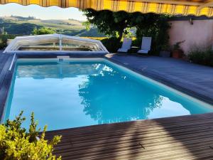a swimming pool with blue water in a backyard at Maison d'hôtes Beauregard in Donneville