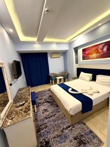 a hotel room with a bed and a tv at La Boutique Residence in Hurghada