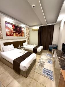 a hotel room with two beds and a painting on the wall at La Boutique Residence in Hurghada