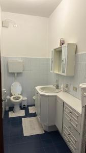 a white bathroom with a toilet and a sink at Thind house in Brescia